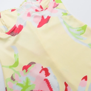 Gros plan d'une robe de printemps avec imprimé floral rouge sur tissu jaune poli