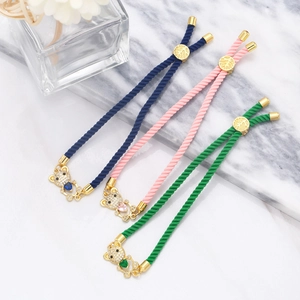 Detail of adjustable woven cord bracelets with gold bear charms and micro-pave zircons
