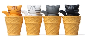 Macro view of four cat resin figurines sitting in yellow waffle ice cream cones