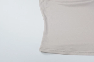 Close-up of high-density knit fabric and precise stitching on the grey tank top hem