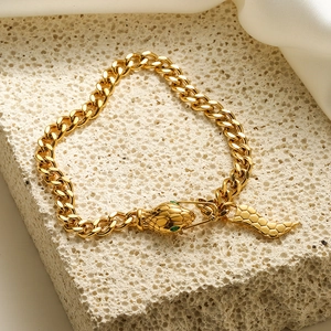 18K gold plated snake head bracelet with green eyes on a minimalist stone base