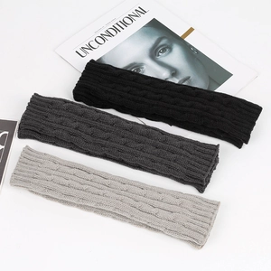 Detail shot of cable knit pattern on fingerless gloves in black, dark grey, and light grey