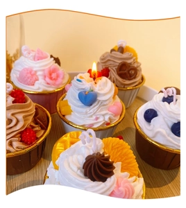 Close-up of dessert cupcake scented candles with cream topping and realistic fruit details