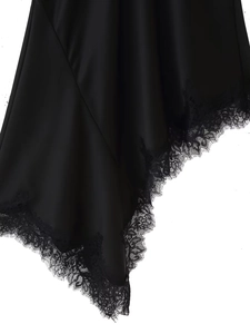 Détail de la robe en satin noir montrant les coutures de dentelle et la texture du tissu