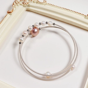 Macro detail of handmade silver-plated wire bracelet with natural freshwater pearls