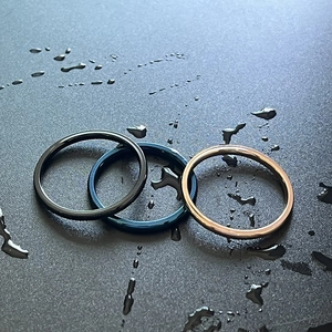Detalle macro de tres anillos minimalistas de acero inoxidable impermeables de 2 mm.