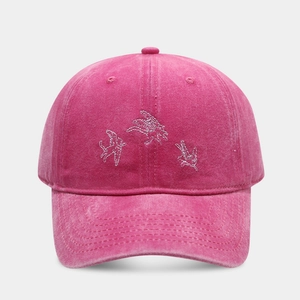 Détail d'une casquette de baseball rose délavée avec broderie d'anges en argent