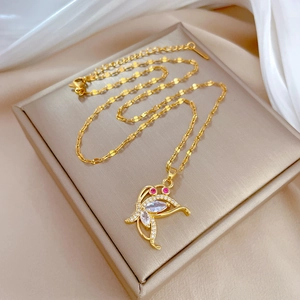 Macro shot of gold butterfly necklace pendant with pink and clear zircon crystals