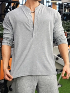 Detail of grey men's long sleeve henley shirt showing knit texture and buttoned collar