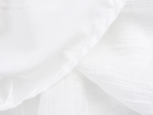 Gros plan sur la texture du tissu en dentelle blanche et les coutures de la robe d'été