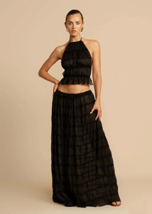 Detail of a black two-piece set featuring halter ruffle crop top and tiered maxi skirt