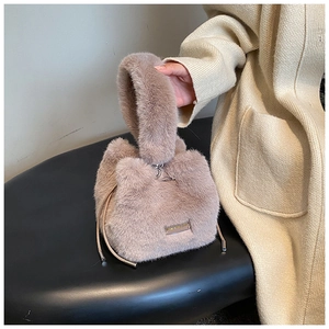 Detail of khaki plush bucket bag showing soft faux fur texture and drawstring closure