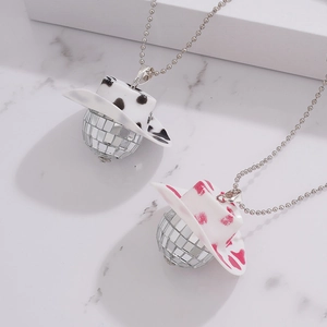 Disco ball necklaces with cow print cowboy hats on a marble background