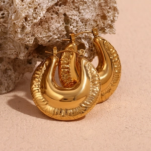 Macro detail of 18K gold plated hoop earrings with vertical ripple texture on stone