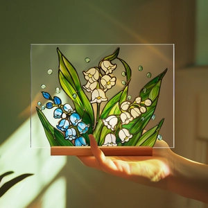 Artistic lily of the valley acrylic decor with wooden base held in natural sunlight