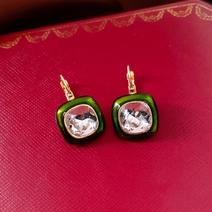 Detail of 18k gold plated square emerald earrings in a luxury red jewelry box