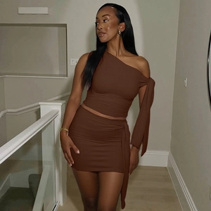 Detail of a brown one-shoulder long sleeve top and ruched bodycon mini skirt set