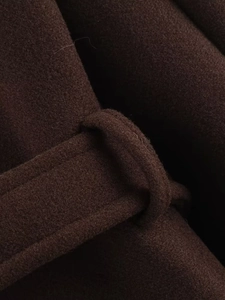 Close-up of deep coffee wool coat fabric texture and waist belt loop detail