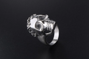 Detailed close-up of a rugged silver skull ring with metallic finish and sharp textures
