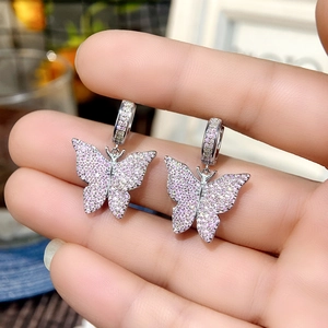 Detail of silver butterfly earrings featuring pink cubic zirconia micro-inlay stones