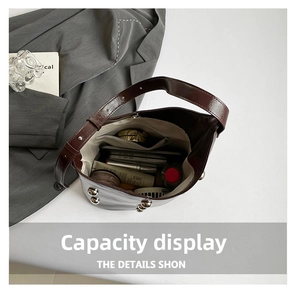 Interior view of large capacity dark brown bucket bag showing daily essentials and rivets