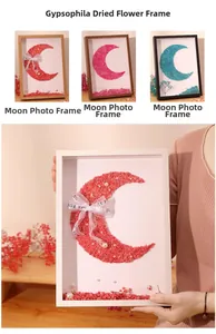 Detail of moon-shaped wooden shadow box frame with dried flowers and ribbon decoration
