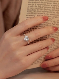 Elegant S925 silver heart moissanite engagement ring on book background
