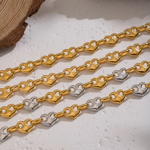 Detail of heart-shaped links in gold and silver mixed stainless steel chain necklace