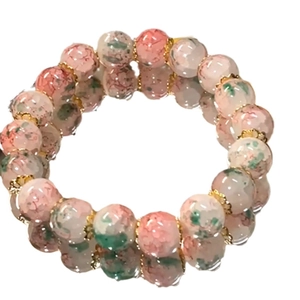 Handmade gradient crackle glass bead bracelet with gold petal spacers on a white base