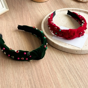 Détail de bandeaux en velours avec nœud, gemmes et perles sur un bureau en bois