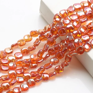 Macro shot of iridescent 12mm rhombus glass beads in orange and amber for DIY crafts