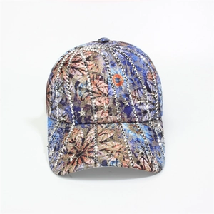 Detail showing colorful floral print baseball cap with silver studs and star accents