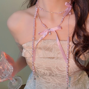 Detail of pink pearl necklace with silk bow and water drop pendant on a model