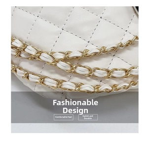Detailed close-up of white quilted crossbody bag with gold chain and fine stitching