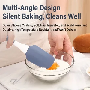 Blue heat-resistant silicone spatula mixing cake batter in a glass bowl kitchen scene