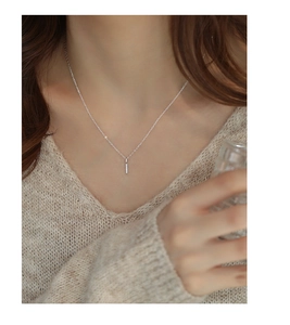 Close-up of minimalist silver bar pendant with tiny zircon pavé on a thin chain