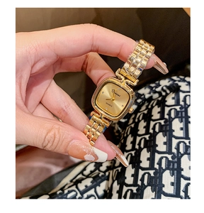 Close-up of elegant gold square quartz watch with steel link band on a female wrist