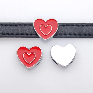 Macro detail of red heart-shaped alloy slider bead on a black 8mm leather wristband