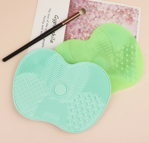 Macro shot of two heart-shaped silicone makeup brush cleaning mats with suction cups