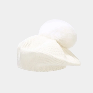 Detailed close-up of white knitted beret featuring a large faux fur pompom decoration