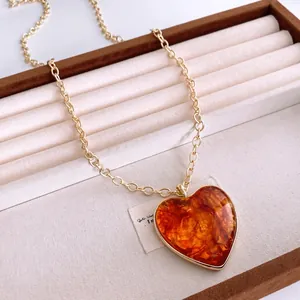 Retro gold chunky chain necklace featuring a heart-shaped amber resin pendant for women