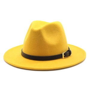 Detailed macro view of yellow wool fedora hat featuring black belt with gold metal buckle