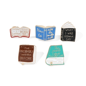 Set of five colorful open book enamel pins with inspirational quotes and gold borders