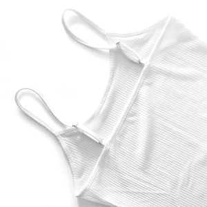 Detail of adjustable shoulder strap and ribbed texture on white camisole dress