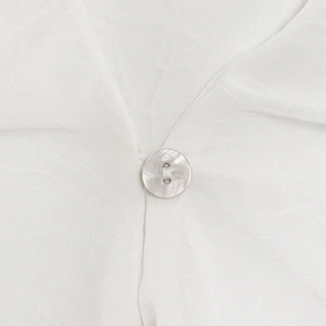 Close-up of minimalist white V-neck blouse featuring breathable fabric and a shell button