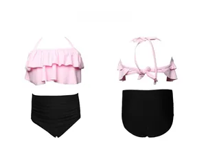 Front and back detail of girls' ruffled halter bikini with high-waisted black swim shorts