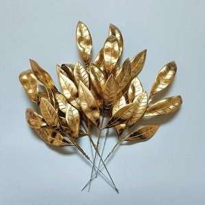 Dettaglio di foglie di pino artificiali dorate con rivestimento metallico natalizio