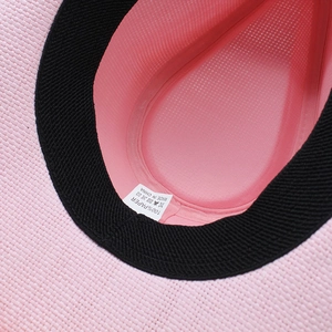 Detail view of pink straw cowboy hat interior showing sweatband and 100% paper material