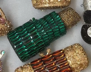 Close-up of luxury lipstick-shaped evening clutch bags with sparkling crystal rhinestones