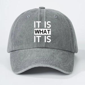 Close-up of gray washed cotton baseball cap with IT IS WHAT IT IS printed text design